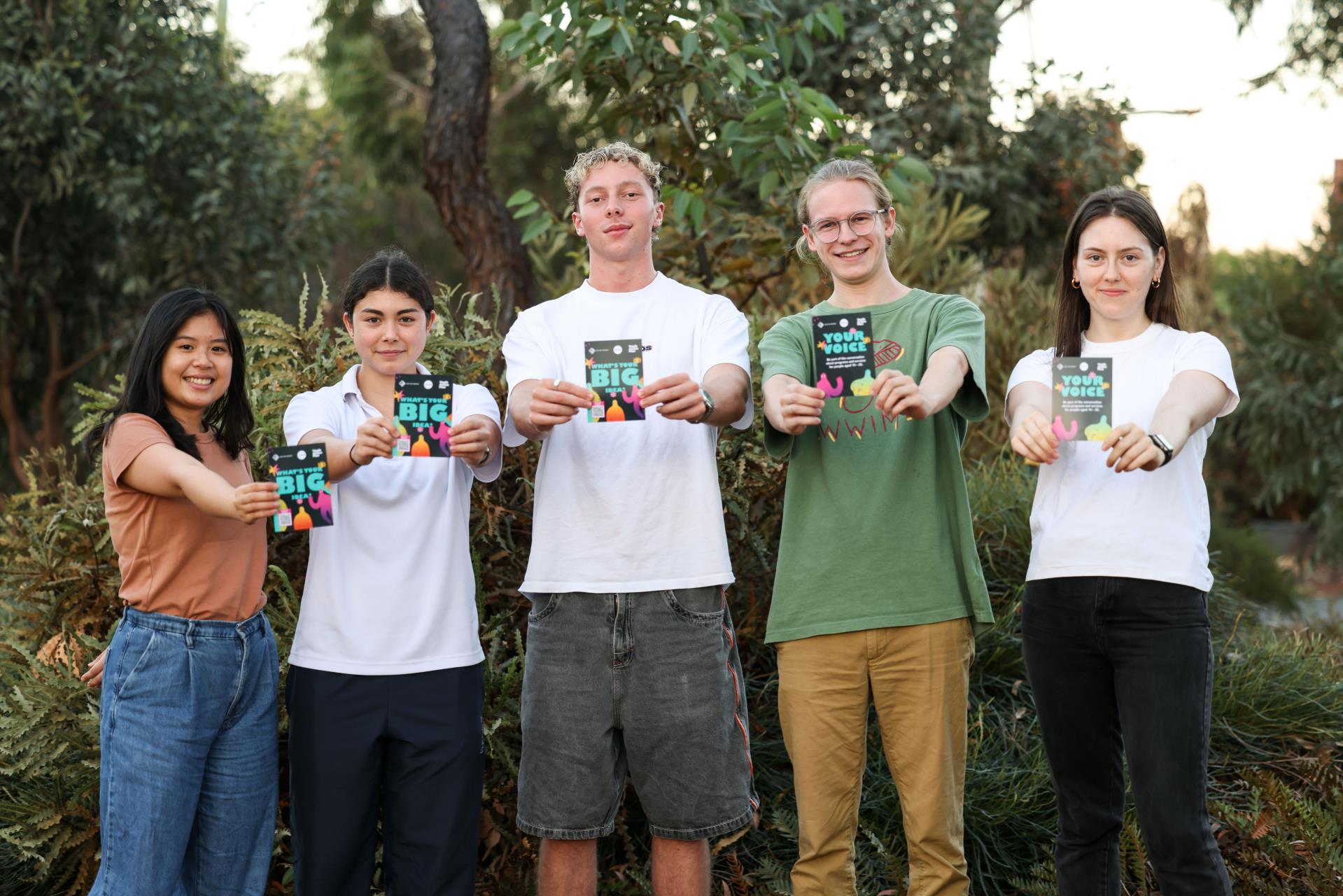 young people holding up Youth Action Plan flyers